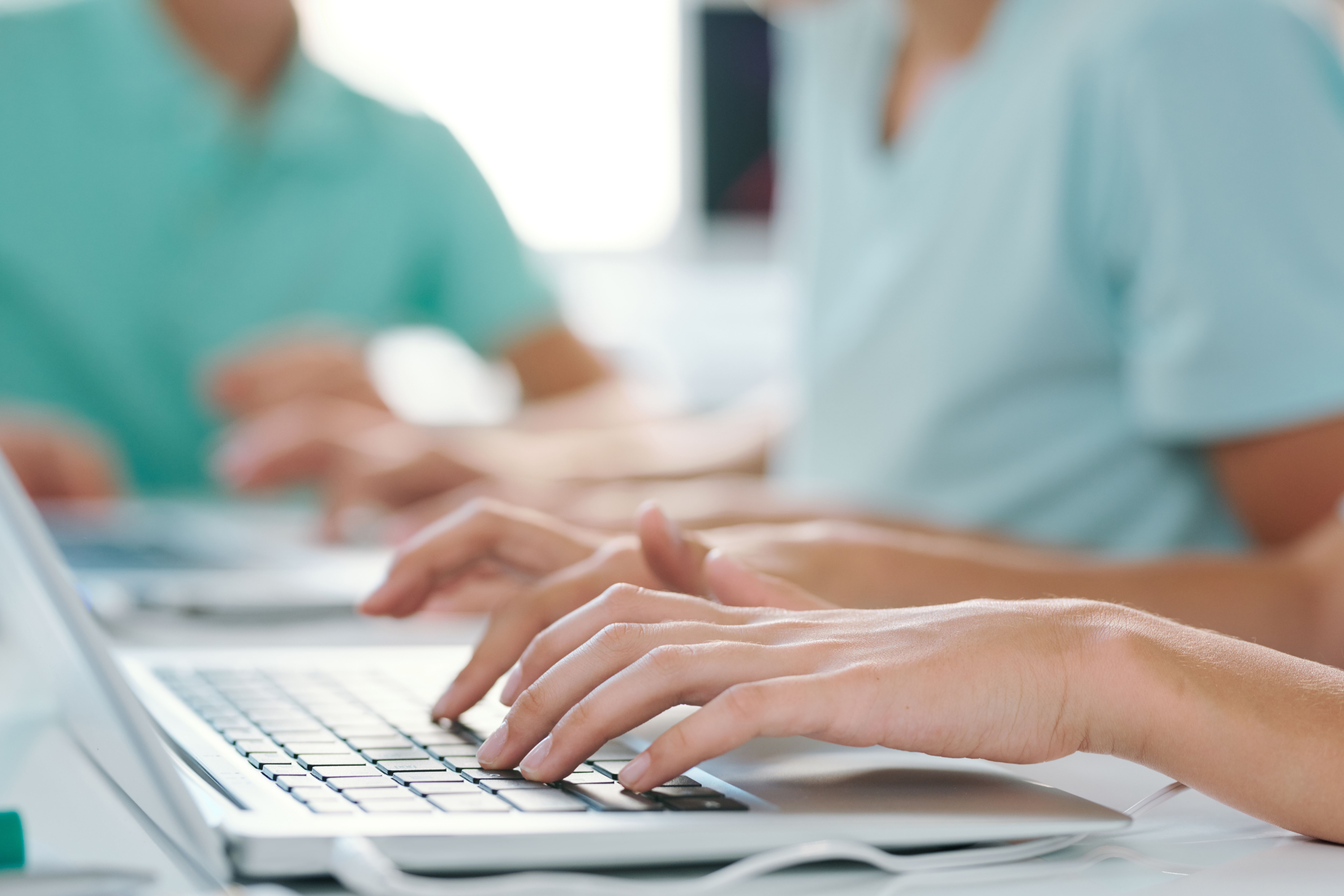 Hands of young female or schoolgirl over keypad of laptop at workplace Hands of young female or schoolgirl over keypad of laptop during work over project or presentation